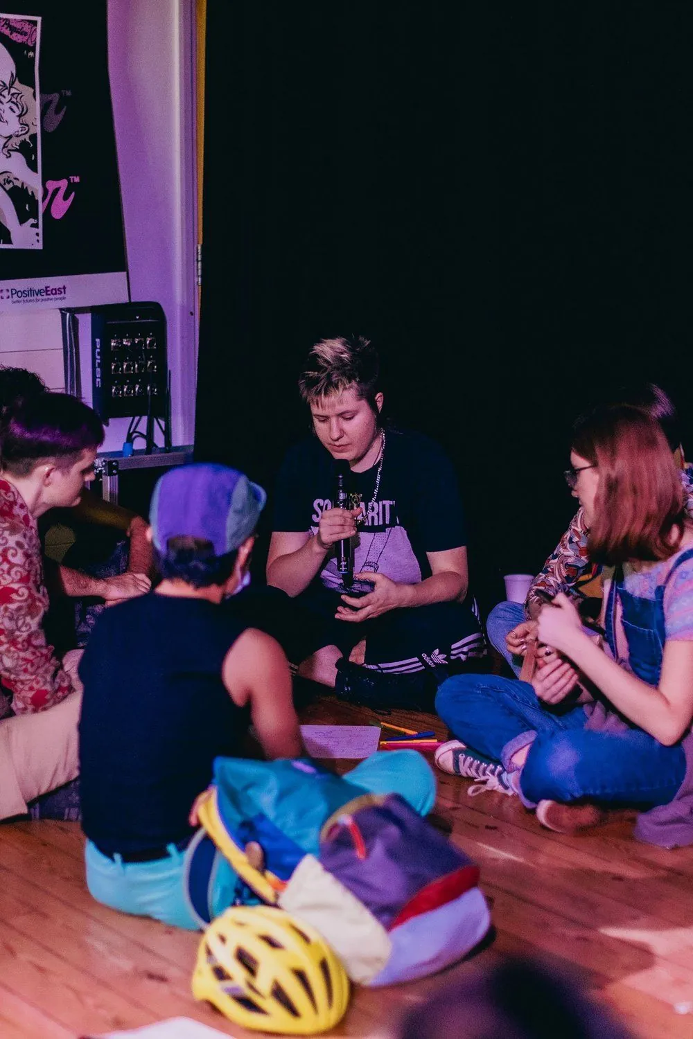 A facilitator holding a microphone in a small discussion circle