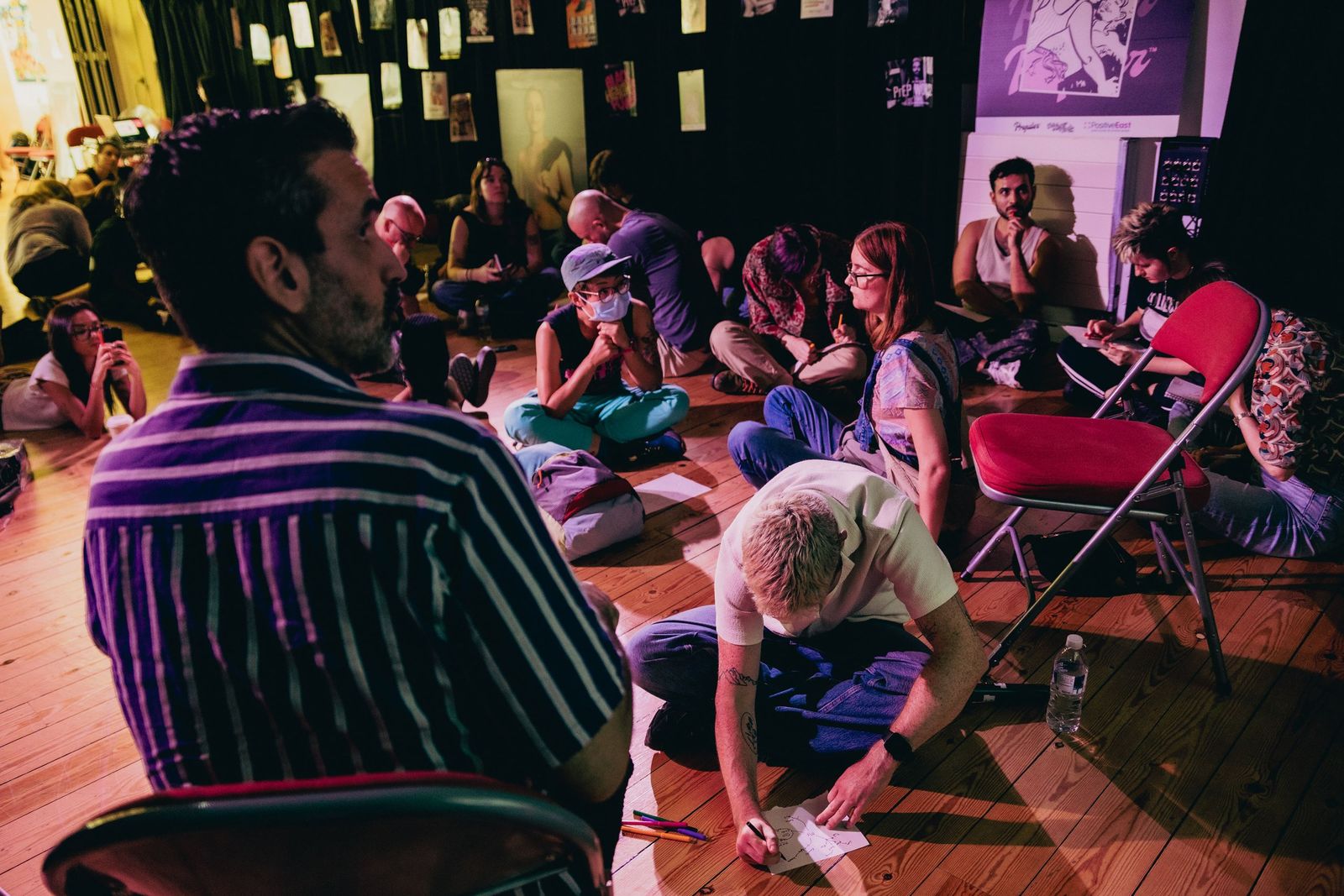Participants sitting in a circle, writing and drawing their chosen family trees